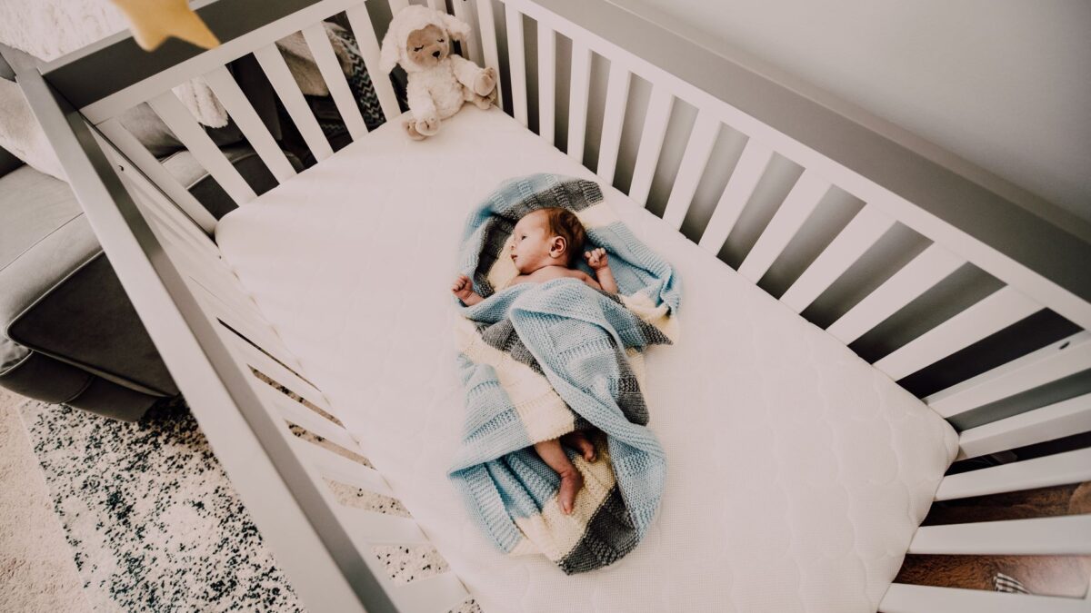 Friedlich schlafendes Baby im Babybett mit Schlafsack