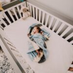 Friedlich schlafendes Baby im Babybett mit Schlafsack