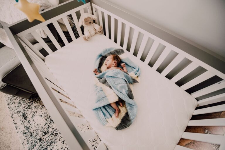 Friedlich schlafendes Baby im Babybett mit Schlafsack