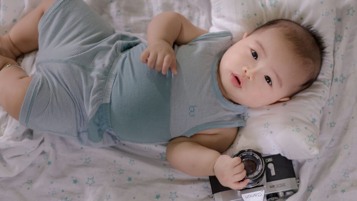 Babyphone mit Kamera steht auf einer Kommode neben dem Babybett