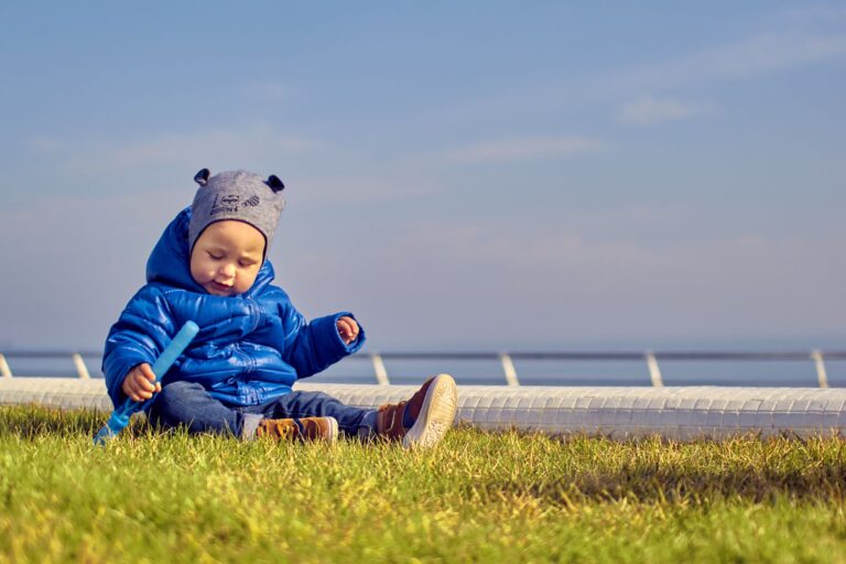 Warm eingepacktes Baby im Winteranzug liegt geschützt im Kinderwagen