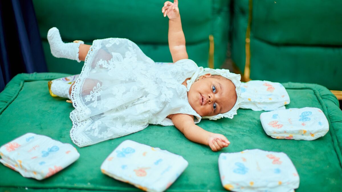 Geöffnete Wickeltasche mit Windeln, Feuchttüchern und Wechselkleidung auf dem Bett